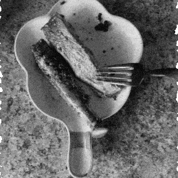 Fork poking on a piece of rib in a flower-shaped plate.